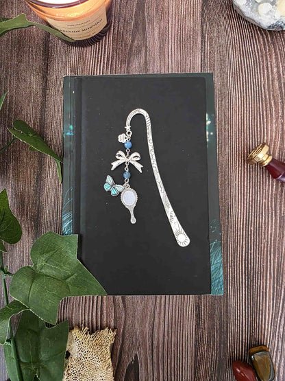 marque-page miroir enchanté, papillon bleu avec un ruban et deux pierres naturelles d'apatite bleue. Le signet est fait à la main par bellette workshop. Ce bijou de lecture est personnalisable